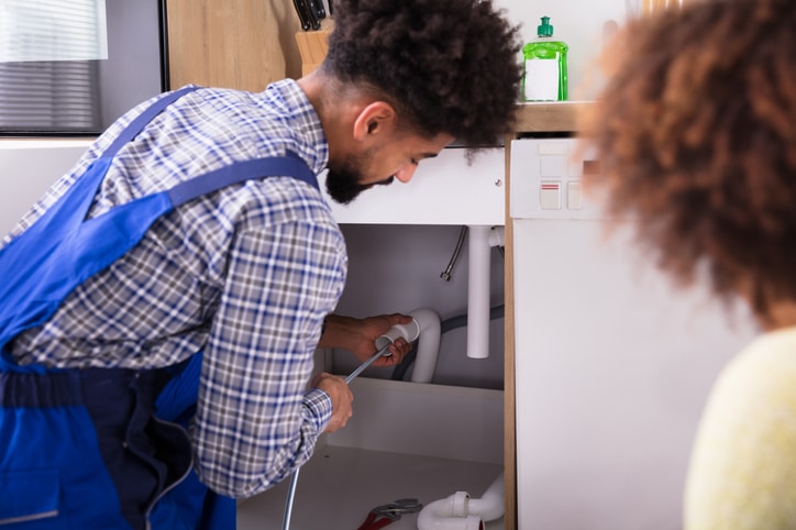 Image of male plumber performing drain cleaning