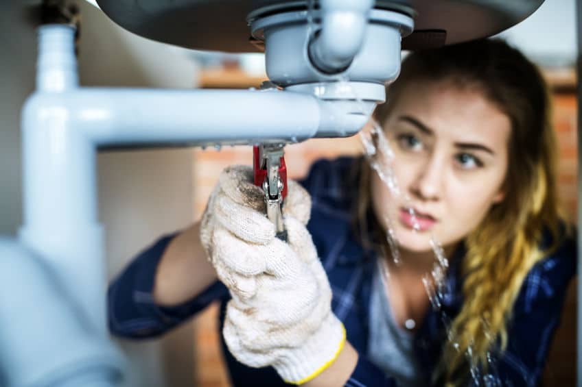 woman making repairs after leak detection